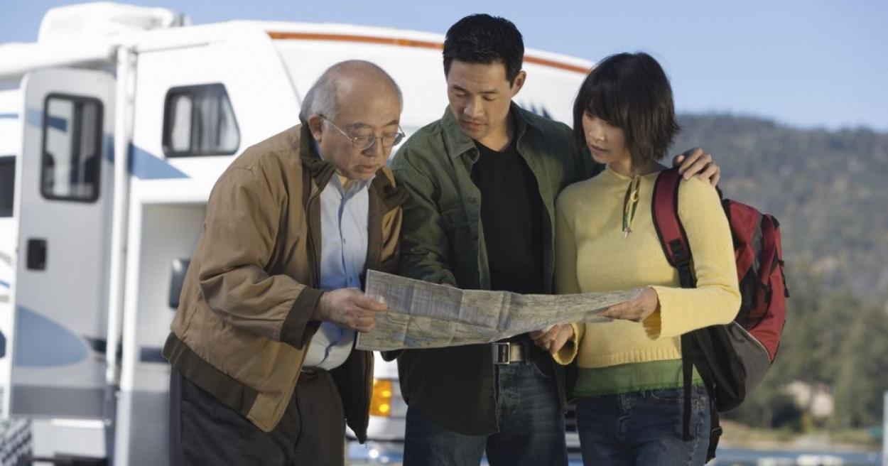 Family looking at a map together outside an RV
