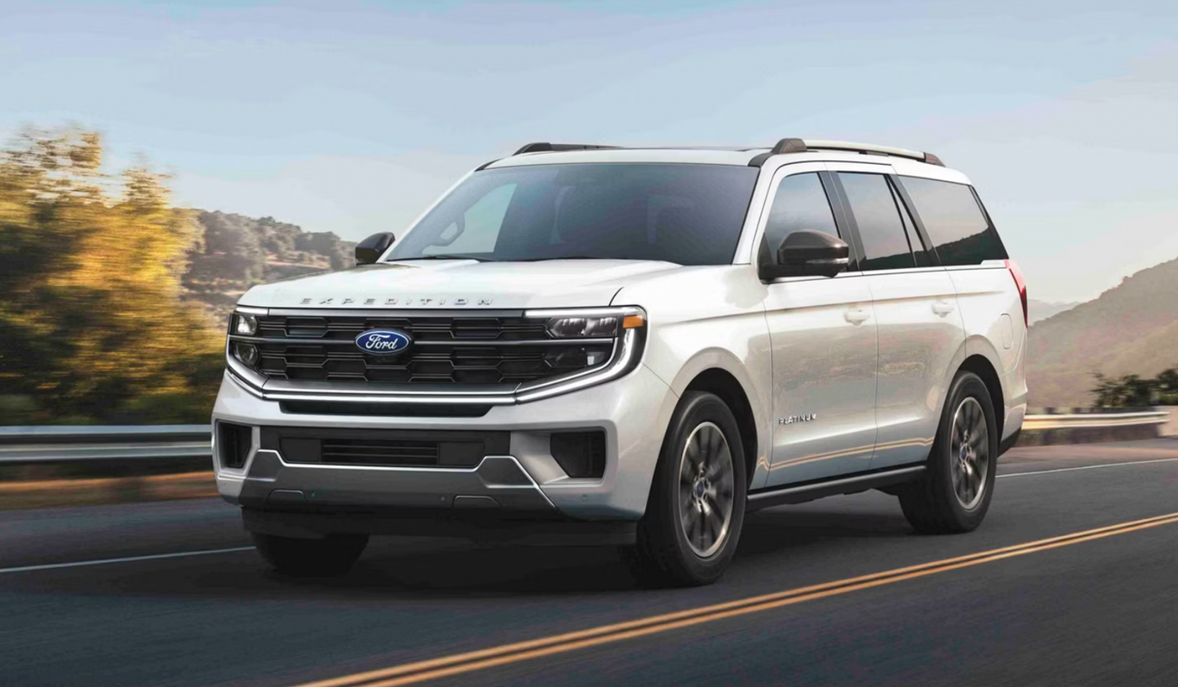 A white Ford Expedition drives down the road