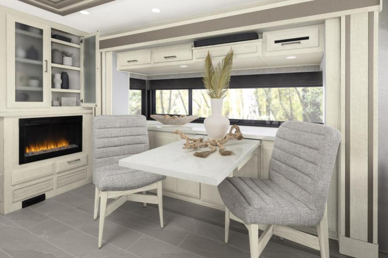 Dining in front of a fireplace inside the 2024 New Aire