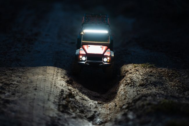 SUV with bright lights headed down a steep incline