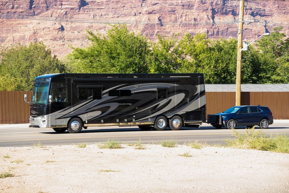 Class A RV towing an SUV