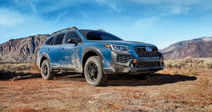 A muddy blue Subaru Outback 