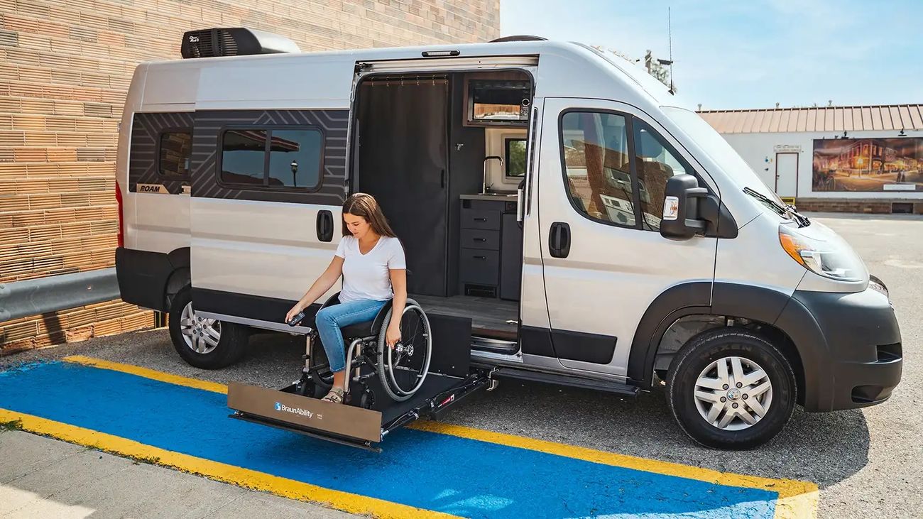 Campervan with woman in a wheelchair on a lift