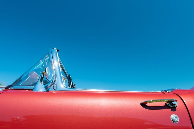 Red convertible against a blue sky
