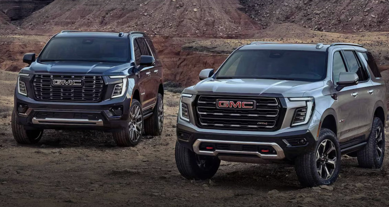 Two GMC Yukons parked in a rocky area