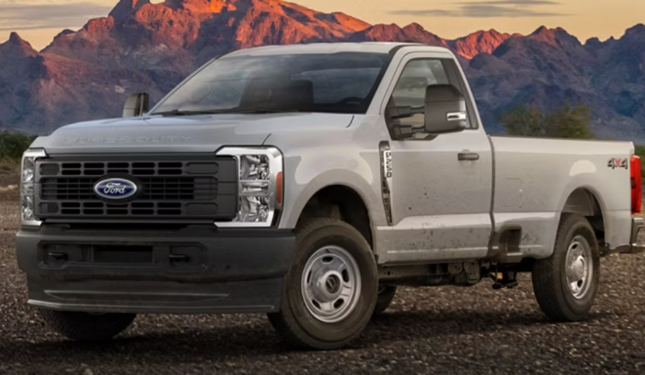 A white Ford Super Duty F-250 parked in front of a mountain range