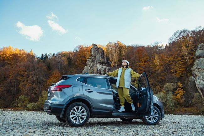 Happy person hanging out the door of an SUV