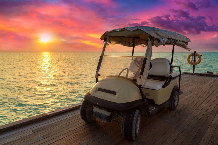 Golf cart in front of a sunset