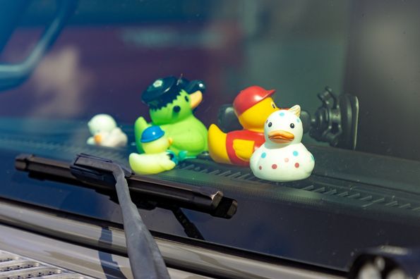 Several colorful ducks on a dashboard