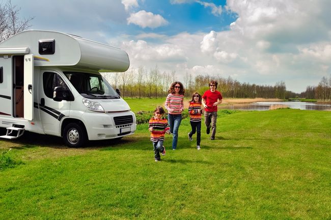 Family running next to an RV