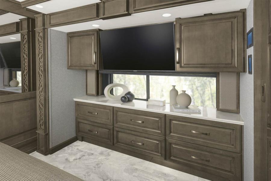 TV and decor objects in the bedroom space of a Class A Luxury RV