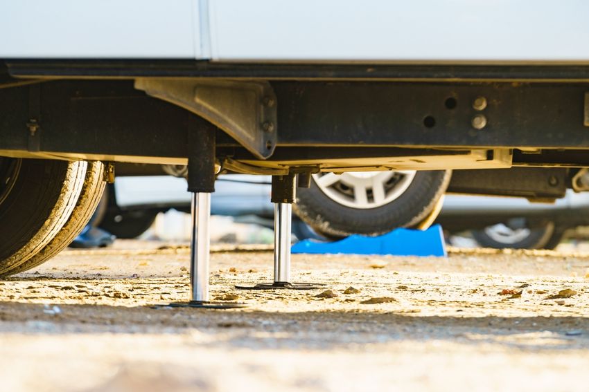Stabilizing jacks engaged under an RV