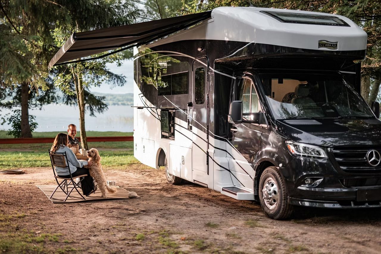 Couple and their dog outside a compact RV