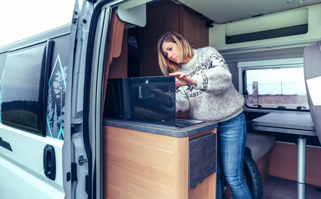 Woman cleans the kitchen inside an RV