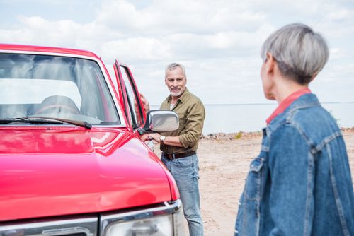 senior couple at tourist spot in pickup truck
