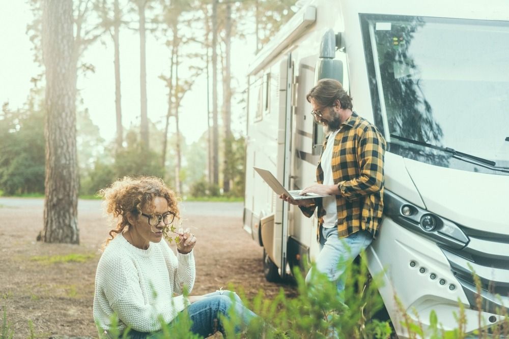 Couple working on computers outside an RV