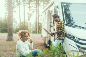 Couple working on computers outside an RV