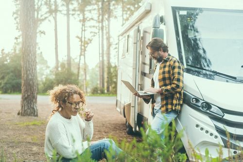 Couple working on computers outside an RV