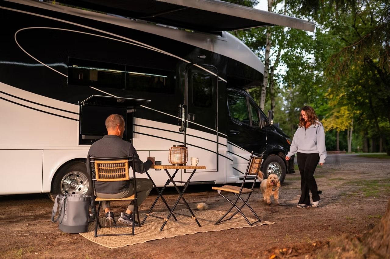 Couple and a dog outside an RV