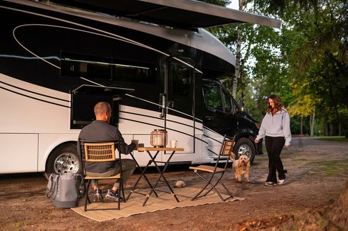 Couple and a dog outside an RV