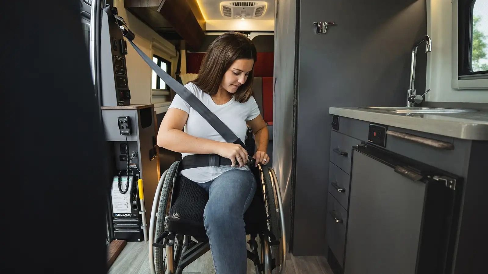 Woman in a wheelchair buckles into an RV