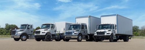 A lineup of different Freightliner trucks.