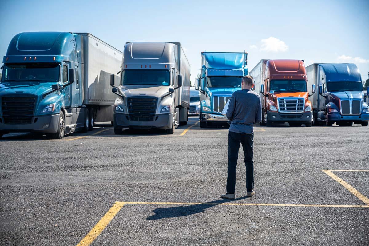 Man standing in front of several semi trucks