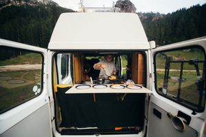 Person cooking in the back of a campervan