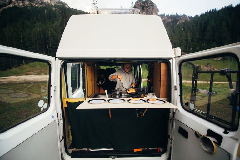 Person cooking in the back of a campervan