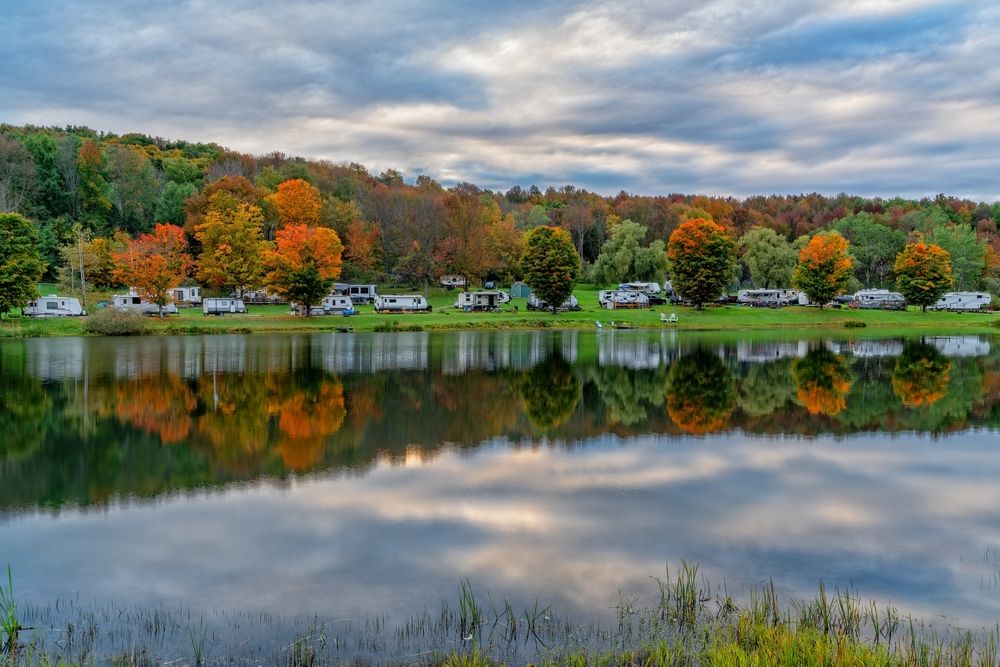 RVs parked next to a lake on an autumn day