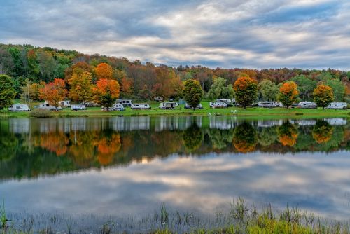 RVs parked next to a lake on an autumn day