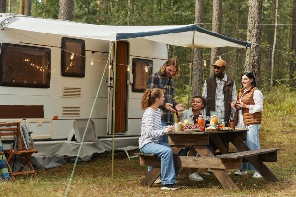 Family enjoying a meal together outside an RV