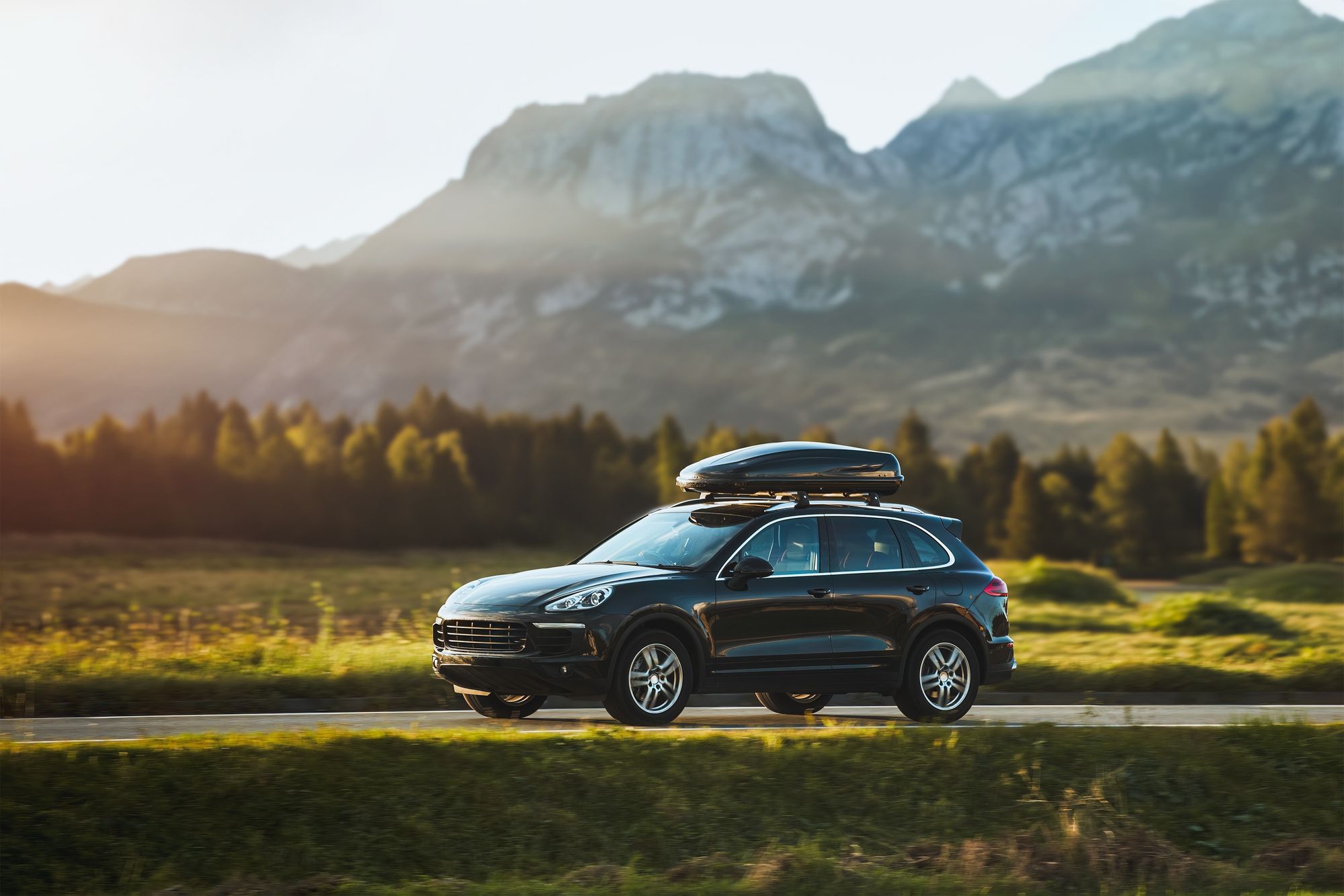 A dark SUV in front of a mountain range