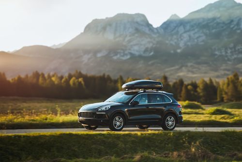 A dark SUV in front of a mountain range