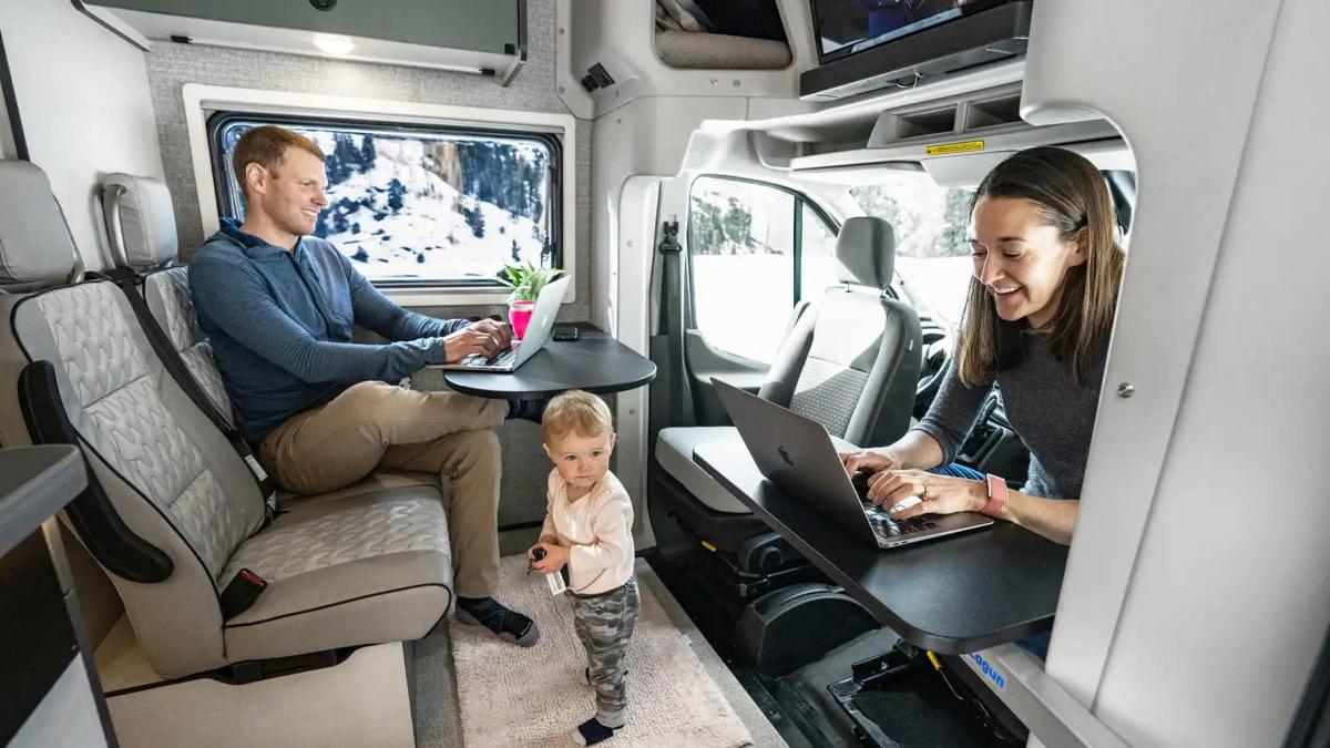 Mother, father, and toddler in the dinette inside a Winnebago Ekko