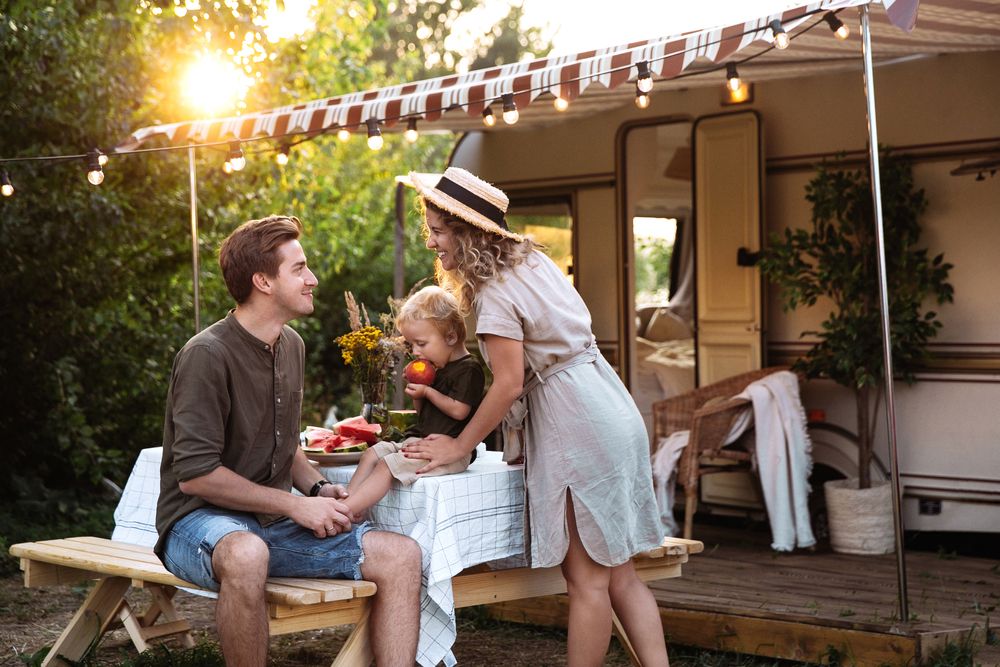 Family of three outside a small campervan