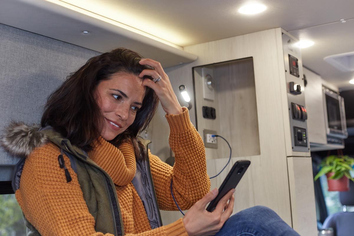 Women inside an RV using her smart phone