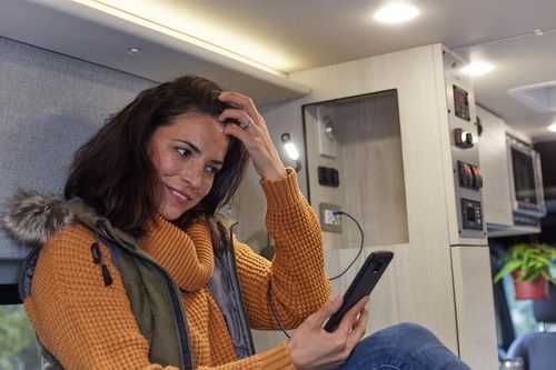 Women inside an RV using her smart phone