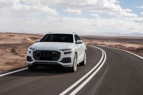 A white SUV driving down the road