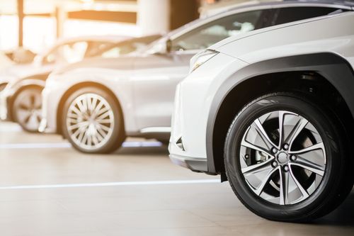 A group of silver cars glimmer in the sunlight