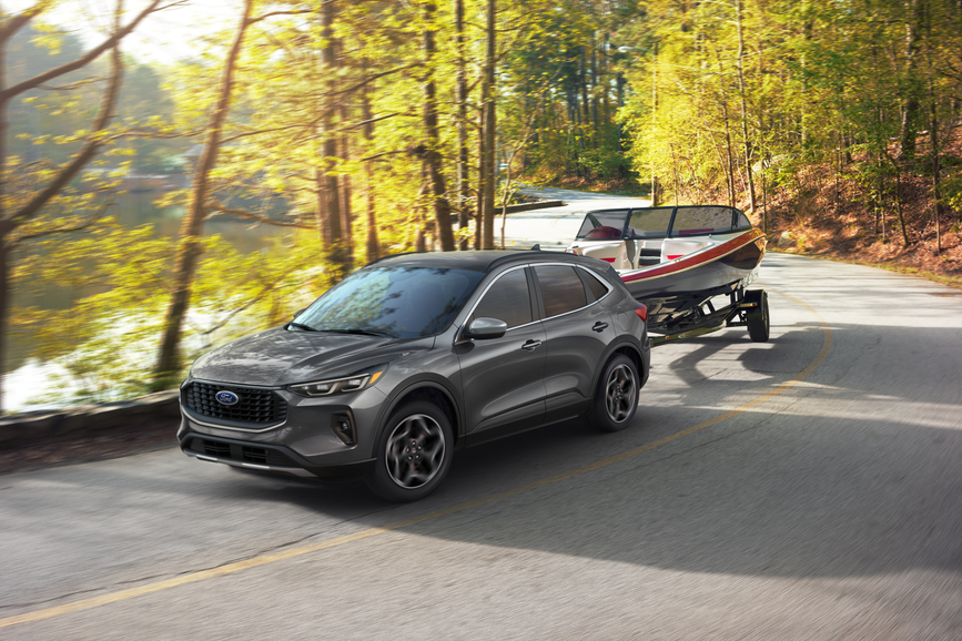 New Ford Escape towing a boat on a highway