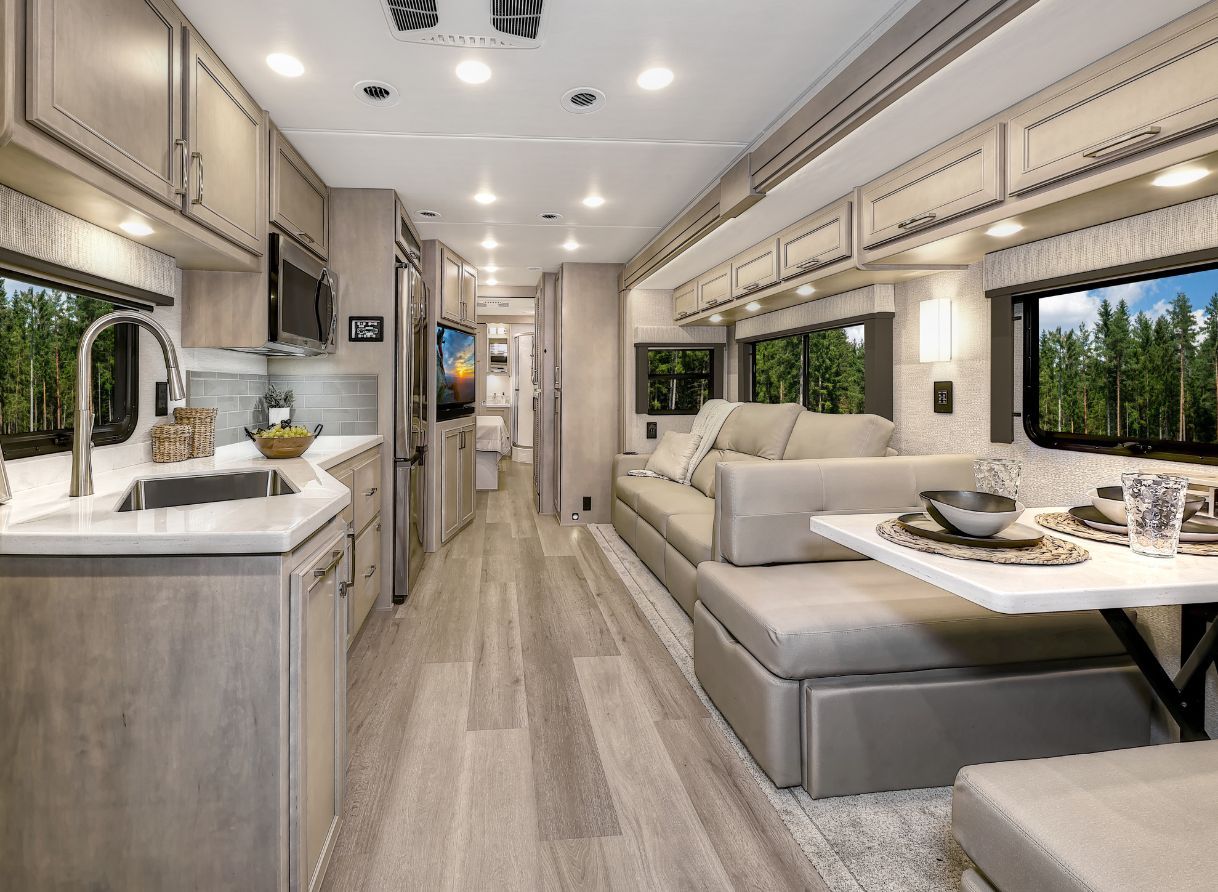 2026 Renegade Verona interior view from kitchen to bedroom with full-wall slide and entertainment center.