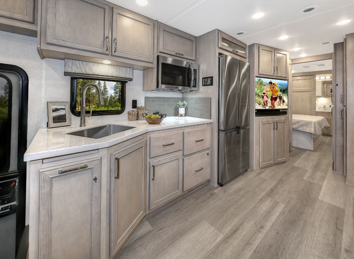2026 Renegade Verona kitchen with refrigerator, stainless sink, convection microwave, and ample cabinetry.
