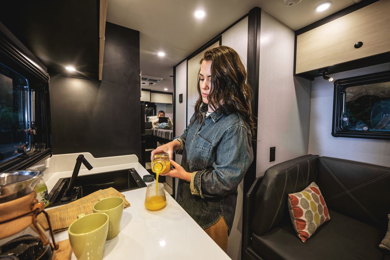 A woman pours orange juice in the 2026 Open Trail&#039;s galley