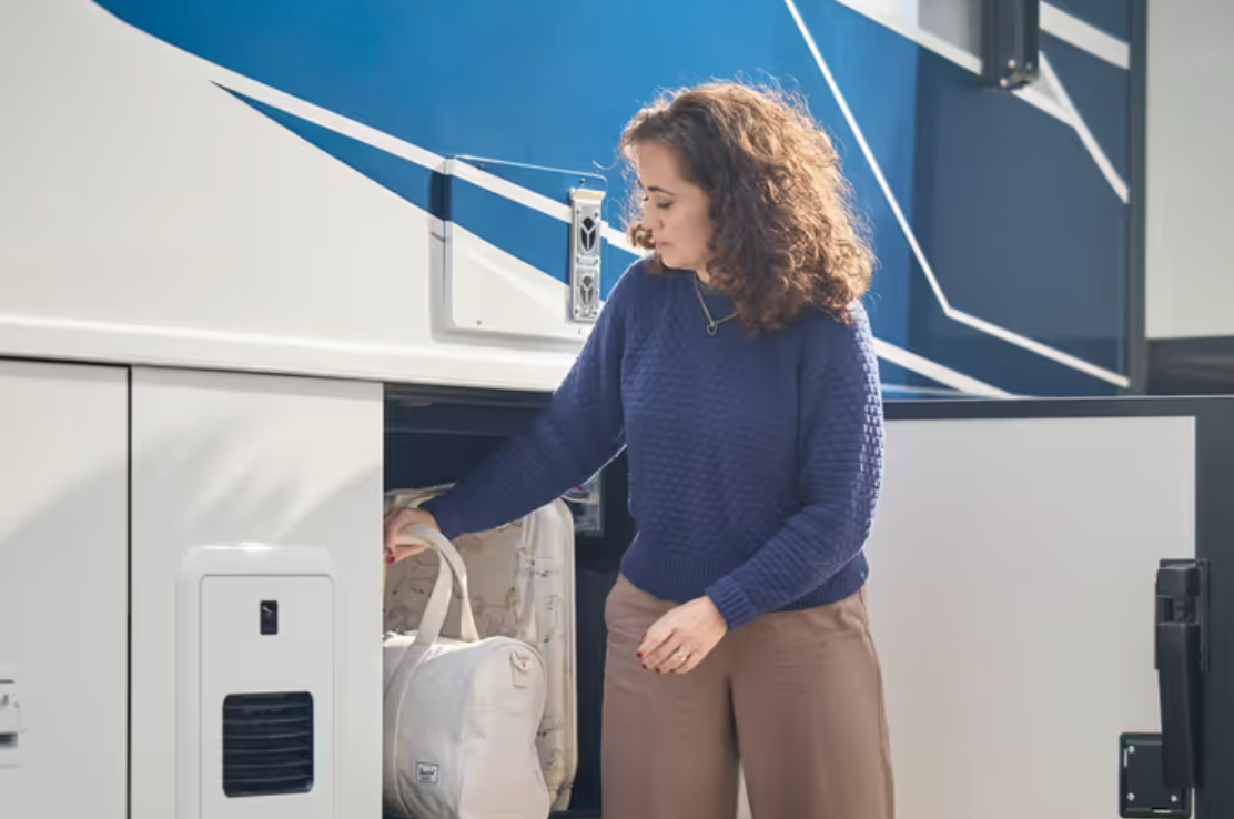 A woman uses the 2026 Bay Star&#039;s exterior storage compartment