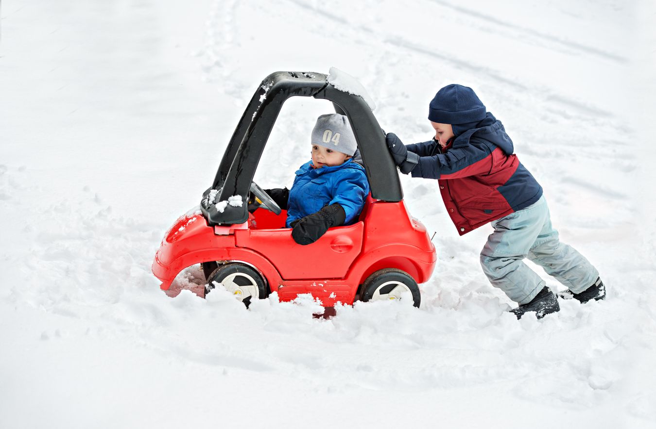 Children playing with toy car in the snow