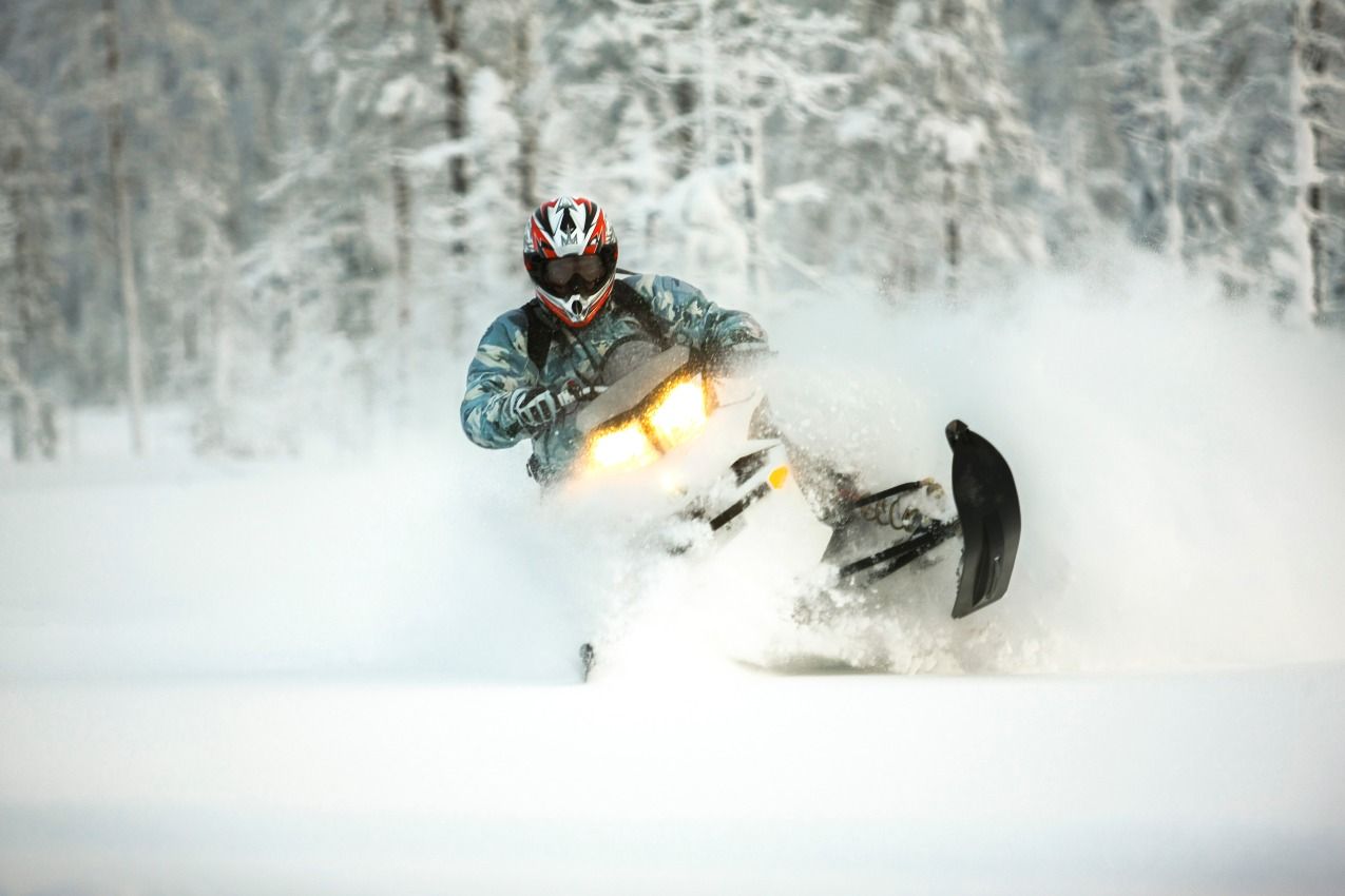 Snowmobiler carving through fresh snow