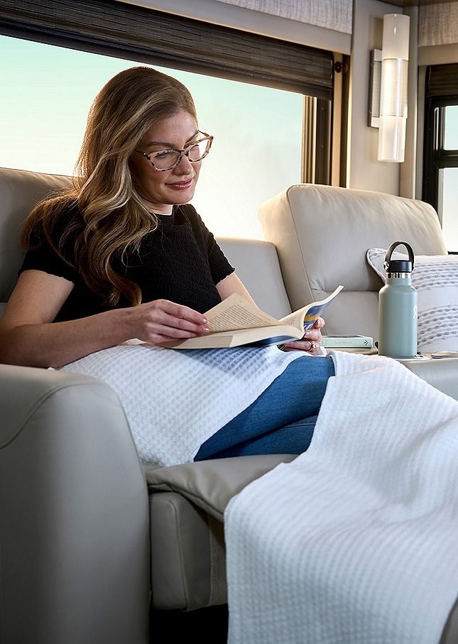 Person inside the 2027 Newmar Mountain Aire reading a book