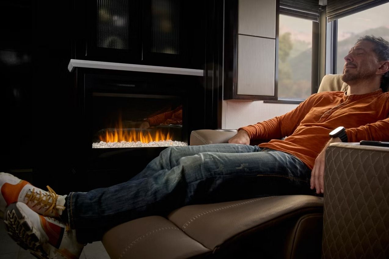 Person lounging in front of a fireplace inside an RV