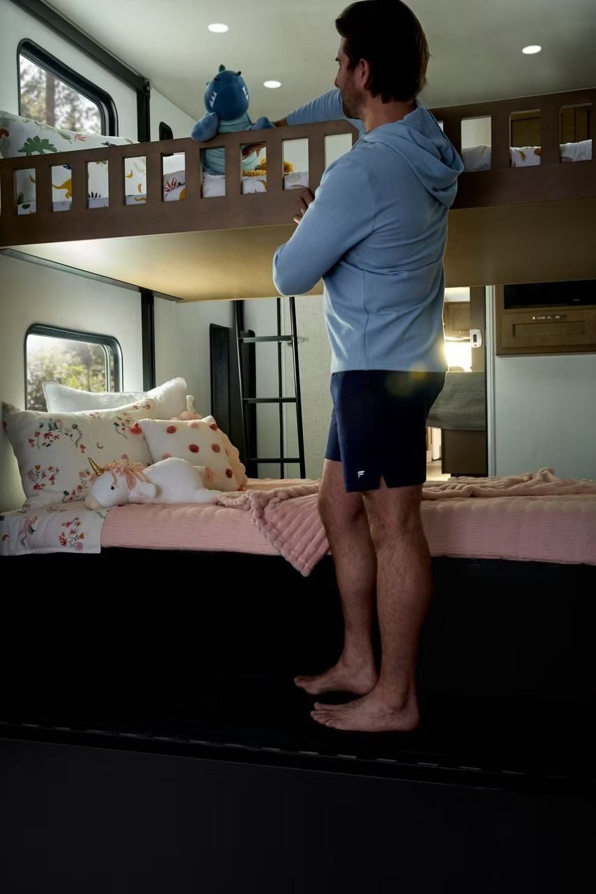 Man next to bunks inside an RV